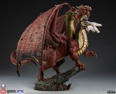 a red dragon figurine is shown on a wooden stand with its mouth open