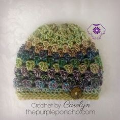 a crocheted hat with a button on the front is shown in multicolors