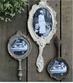 three antique mirrors are hanging on a wooden wall next to a potted plant and two spoons