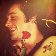 a man with a rose tattoo on his shoulder