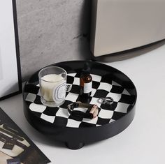 a black and white checkered tray with a candle