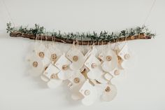 christmas stockings hanging from a tree branch with buttons on them and other ornaments attached to it