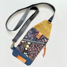 a multicolored purse with an id holder attached to the front and shoulder strap