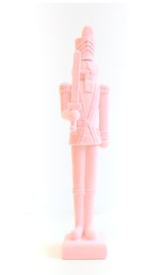 a pink toy soldier is standing on a white surface