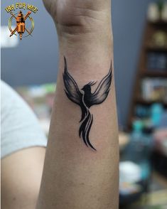 a black and white bird tattoo on the wrist