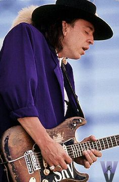 a painting of a man with a hat and guitar in front of blue sky background