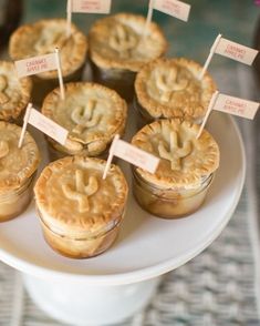 small pies on a white plate with name tags attached to the top and bottom