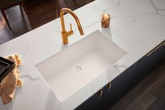 a white sink sitting under a faucet on top of a counter next to a phone