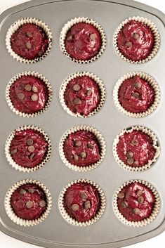 cupcakes with chocolate chips in them sitting on a baking tray ready to go into the oven