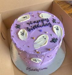 a purple birthday cake with white frosting in a box