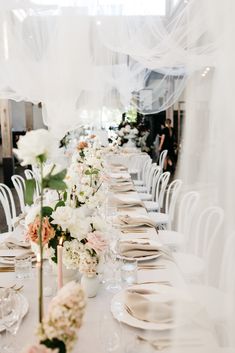 a long table is set with white and pink flowers