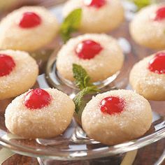 small desserts on a glass plate with mint garnishes and powdered sugar