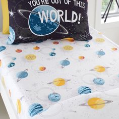 a bed with a pillow that says you're out of this world