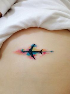 a woman's stomach with an airplane tattoo on it