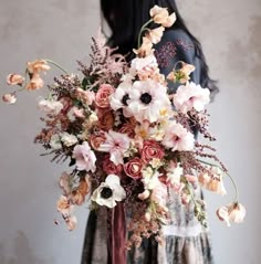 a woman holding a bouquet of flowers in her hands