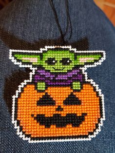 a close up of a person wearing a blue jean jacket with an orange pumpkin on it