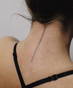 the back of a woman's neck is shown with small dots on her left side