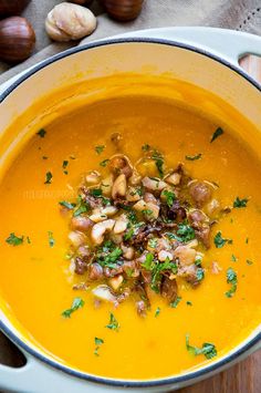 a bowl of soup with nuts and parsley