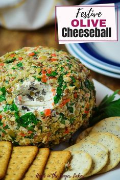 a cheese ball on a plate with crackers next to it and the words festive olive cheeseball