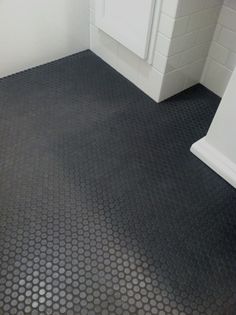 a bathroom with a black floor and white walls