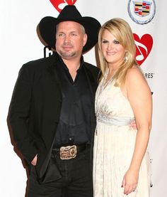 a man and woman standing next to each other on a red carpet