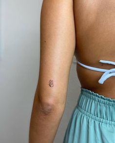 a woman with a small tattoo on her left arm and the back of her body