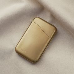 a gold lighter laying on top of a white cloth