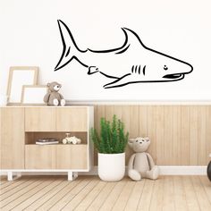 a shark wall decal in a child's room with a teddy bear next to it