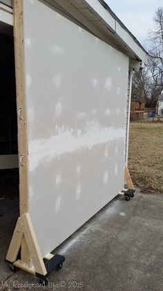 a white garage door being installed to the side of a house