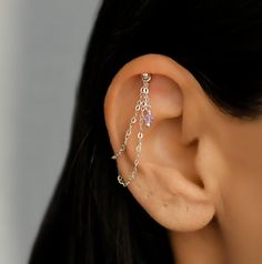 a close up of a person's ear with a chain attached to the side