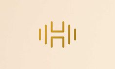 the letter h is made up of thin lines and gold foil on a beige background