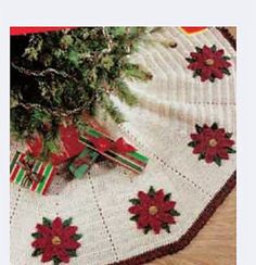 a white table cloth with red poinsettis on it and a vase filled with flowers