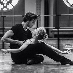 two people sitting on the floor in front of stained glass windows, one man is kissing the other woman's head