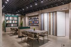 a room filled with lots of tables and chairs next to bookshelves full of books