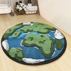 a round rug with a green and blue world map on it in the middle of a wooden floor