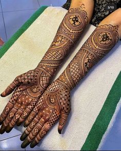 two hands with henna tattoos on them