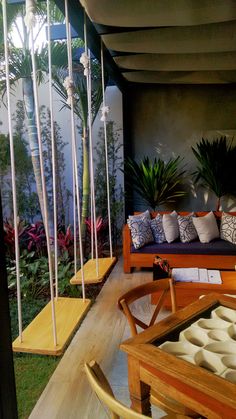 an outdoor living area with wooden furniture and plants