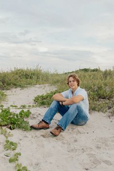 a man sitting in the sand with his legs crossed