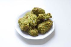 a white bowl filled with green food on top of a table