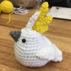 a crocheted bird is sitting on the table