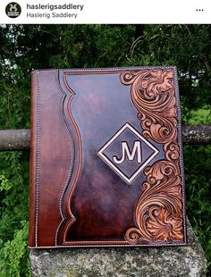 a brown leather journal sitting on top of a rock