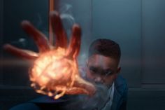 a man in a suit is holding out his hand with flames coming out of it