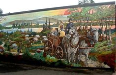 a mural painted on the side of a building with people riding in a horse drawn carriage