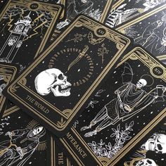 four tarot cards with skulls and skeletons on them, all in black and gold