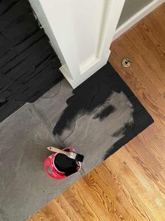 a pair of red shoes sitting on top of a wooden floor next to a door