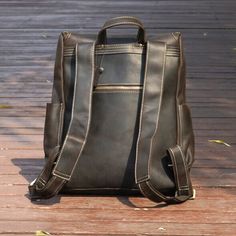 Elevate your daily commute with our Vintage Leather Backpack, seamlessly combining timeless style with practical functionality.   Crafted from heavy duty genuine leather, this rucksack not only exudes a vintage charm but also ensures lasting durability. The spacious interior is thoughtfully designed to accommodate your everyday essentials, featuring a dedicated laptop sleeve (fits laptop up to 15. 6''), wide shoulder straps for comfort, convenient side pockets, and elegant brass metal parts. Outer 100% vegetable tanned, genuine saddle (cowhide) leather, which develops worn look patina. Inner 30% cotton, 70% polyester, cloth lined. Use professional leather caring kit. Patina is the unique character of the saddle leather. Rub at the patina with your fingers to lighten it.  Adjustable wide sh Vintage Leather Backpack, Knit Loungewear, Stocking Fillers For Her, Brand Magazine, Saddle Leather, Brass Metal, Everyday Essentials, Gifts For Mum, Laptop Sleeve