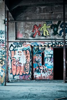 an old building with graffiti all over the walls and doorways that are covered in spray paint