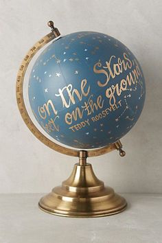 a blue and gold globe with writing on it that says, see your own land