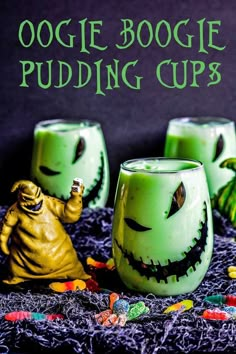 three green halloween pudding cups with spooky faces and candy on the bottom one has a yellow ghost figure