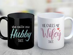 two black and white coffee mugs sitting next to each other on top of a table